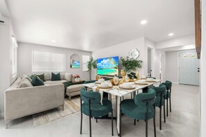 A modern living room with a dining area, a sofa, and a TV. - Ranch-Style w Gated Yard, 4 Parking, 4 Bedroom 3 Bathroom (La Mesa)