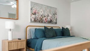 A bedroom with a bed, bedside tables, a mirror, and a floral painting on the wall. - Ranch-Style w Gated Yard, 4 Parking, 4 Bedroom 3 Bathroom (La Mesa)