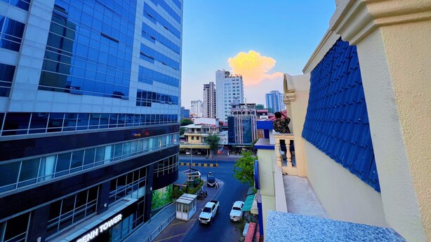 A high-rise building with a glass facade, a street with vehicles, and a clear sky. - A Z Hotel Phnom Penh (Phnom Penh)