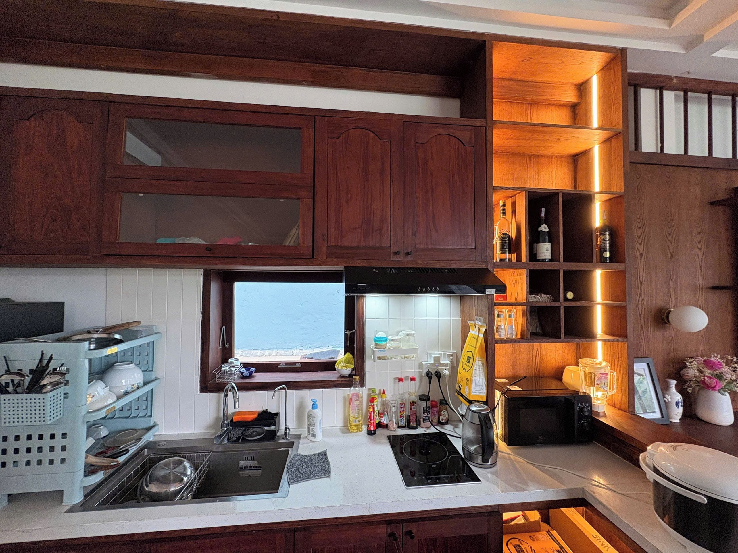 A kitchen with wooden cabinets, a built-in microwave, and a window overlooking a scenic view.