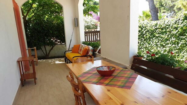 A wooden dining table with chairs, a small wooden side table, and a colorful placemat. - Villa Marisol with parking space and large garden (San Pietro In Bevagna)