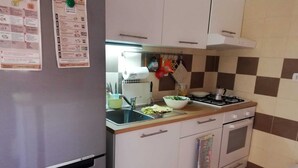 A compact kitchen with a refrigerator, sink, stove, and a small oven. - Villa Marisol with parking space and large garden (San Pietro In Bevagna)