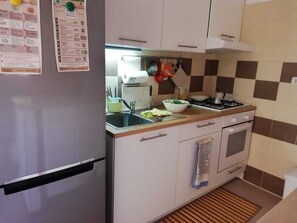 A compact kitchen with a refrigerator, sink, stove, and a small oven. - Villa Marisol with parking space and large garden (San Pietro In Bevagna)