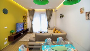 Una sala de estar moderna con sofá, televisión y objetos decorativos.
