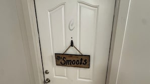 Eine weiße Tür, an der ein Schild mit der Aufschrift 'The Smoots' hängt.