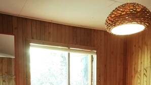 A wooden-paneled room with a bed, a bench, a heater, and a window. - Casa del Estero in downtown Pucón (Pucon)