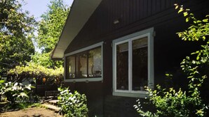 A house with a covered porch, a stone foundation, and a window with a white frame. - Casa del Estero in downtown Pucón (Pucon)