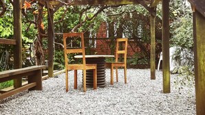 A wooden pergola with a table and chairs in a garden area. - Casa del Estero in downtown Pucón (Pucon)