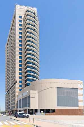 Ein hohes Gebäude mit einer geschwungenen Fassade, großen Fenstern und einem flachen Dach.