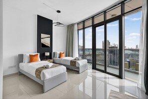 A modern hotel room with two beds, a large window with a city view, and a minimalist design. - Silkhaus Premium 2bdr in Julphar Near Reem Park (Abu Dhabi)