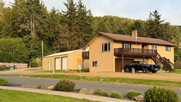 A two-story house with a balcony, a garage, and a truck parked in front. - Captain Kujo’s Hideaway (Depoe Bay)