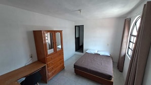 A bedroom with a bed, a wooden dresser, a desk, and a mirror. - Hospedaje Casa Vazquez Sucursal Calle 30 (Pachuca)