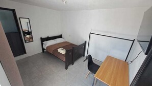 A small, single-bed room with a desk and chair, a mirror, and a window. - Hospedaje Casa Vazquez Sucursal Calle 30 (Pachuca)