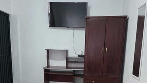 A bedroom with a bed, a desk, a wardrobe, and a TV on the wall. - Hospedaje Casa Vazquez Sucursal Calle 30 (Pachuca)