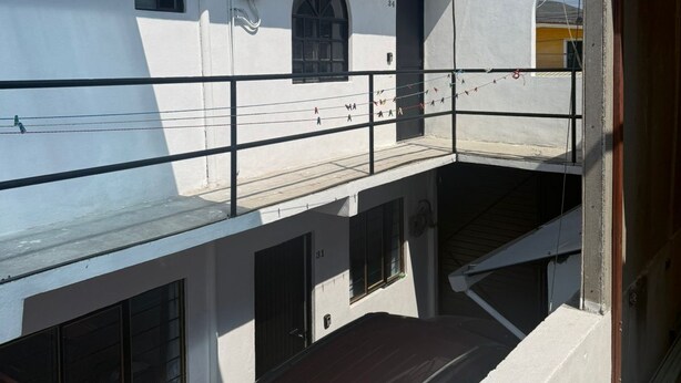 A multi-story building with a balcony, a car parked in front, and a clear sky. - Hospedaje Casa Vazquez Sucursal Calle 30 (Pachuca)