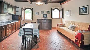 Una cucina con tavolo e sedie da pranzo, un divano e una televisione.