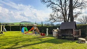 A playground with slides and climbing structures, a bench, and a small shed. - Cozy apartment in Montecatini Val di Cecina (Montecatini Val di Cecina)