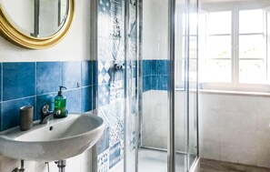 Ein Badezimmer mit Waschbecken, Spiegel und Dusche.