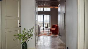 A hallway with a door, a vase with green foliage, a red chair, and a table with a bowl. - 1 bedroom cozy home in Kivik (Kivik)