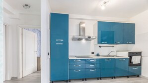 Eine moderne Küche mit blauen Schränken, einer Edelstahl-Dunstabzugshaube und einem eingebauten Backofen.