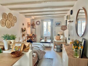 A cozy living room with a sofa, a dining table, a bookshelf, and a large mirror. - The Ochre Hut -Quiet & Peaceful- by Mon Petit Fare (Bourges)