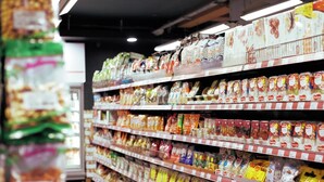 Un corridoio di un negozio di alimentari con diversi prodotti confezionati sugli scaffali.