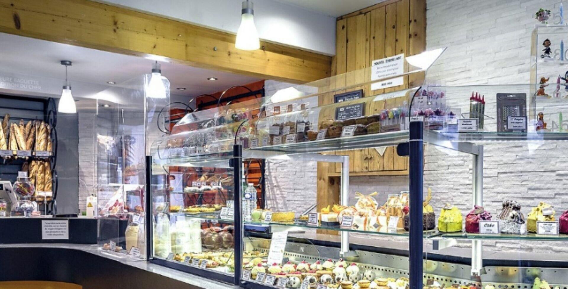 Eine Backvitrine mit verschiedenen Backwaren und einer Holzzieldecke.