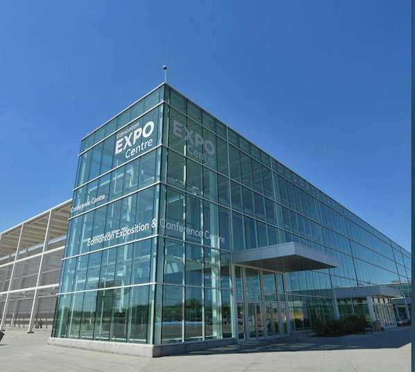 En modern byggnad med glasfasad och skylten ”EXPO Centre”, vilket visar att det är en konferens- eller utställningsanläggning.