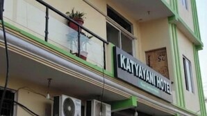 En tvåvåningsbyggnad med en skylt som visar texten ”Katyayani Hotel”.