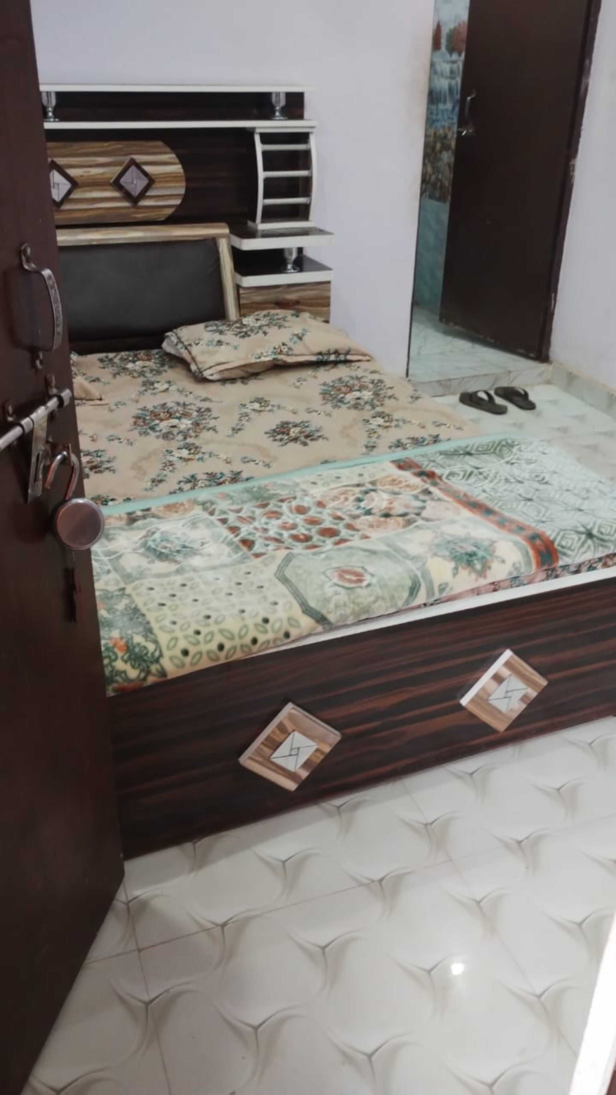 A bedroom with a bed, a dresser, a mirror, and a door.