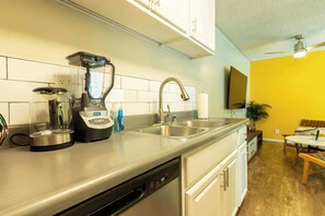A modern kitchen with a built-in dishwasher, a coffee maker, and a sink. - Sleek And Chic Getaway (Beverly Hills)