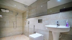 A modern bathroom with a shower, toilet, and sink. - 7 The Business Hotel (Aluva)