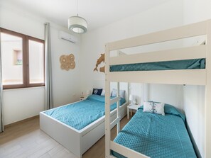 A room with two bunk beds, a window, and a wall-mounted air conditioner. - Appartamento con Aria Condizionata (Trinità d'Agultu e Vignola)