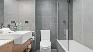 Un baño moderno con ducha, inodoro y lavamanos.