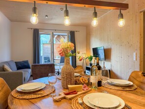 Una mesa de comedor dispuesta con platos, copas de vino y un florero con flores.