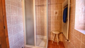 Ein Badezimmer mit Dusche, Toilette und Handtuchhalter.