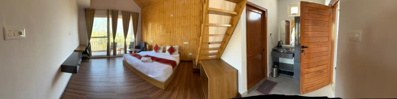 Une chambre à coucher avec un lit, un escalier en bois, une salle de bain et un balcon.