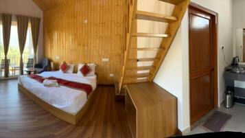 Une chambre à coucher avec un lit, un escalier en bois, une salle de bain et un balcon.