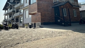 Un immeuble à plusieurs étages doté de balcons, d’un escalier et d’un espace de stationnement pour motos.