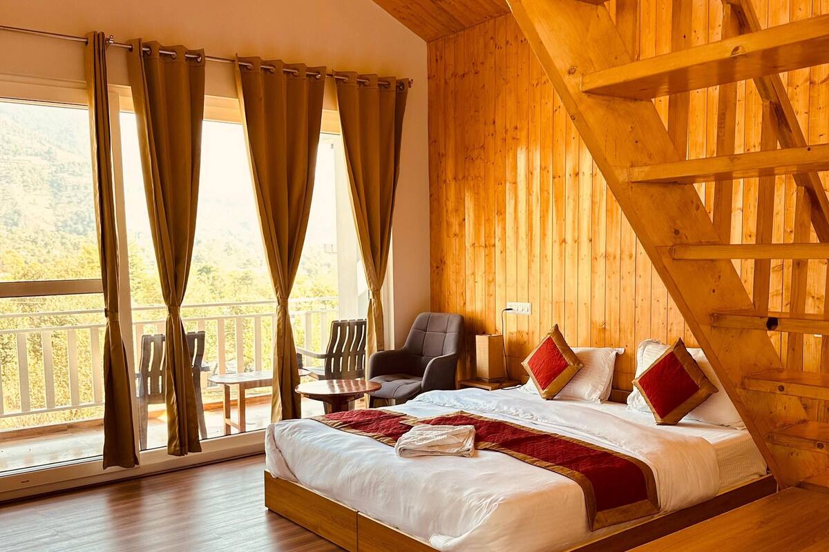 A wooden room with a bed, a chair, and a table.
