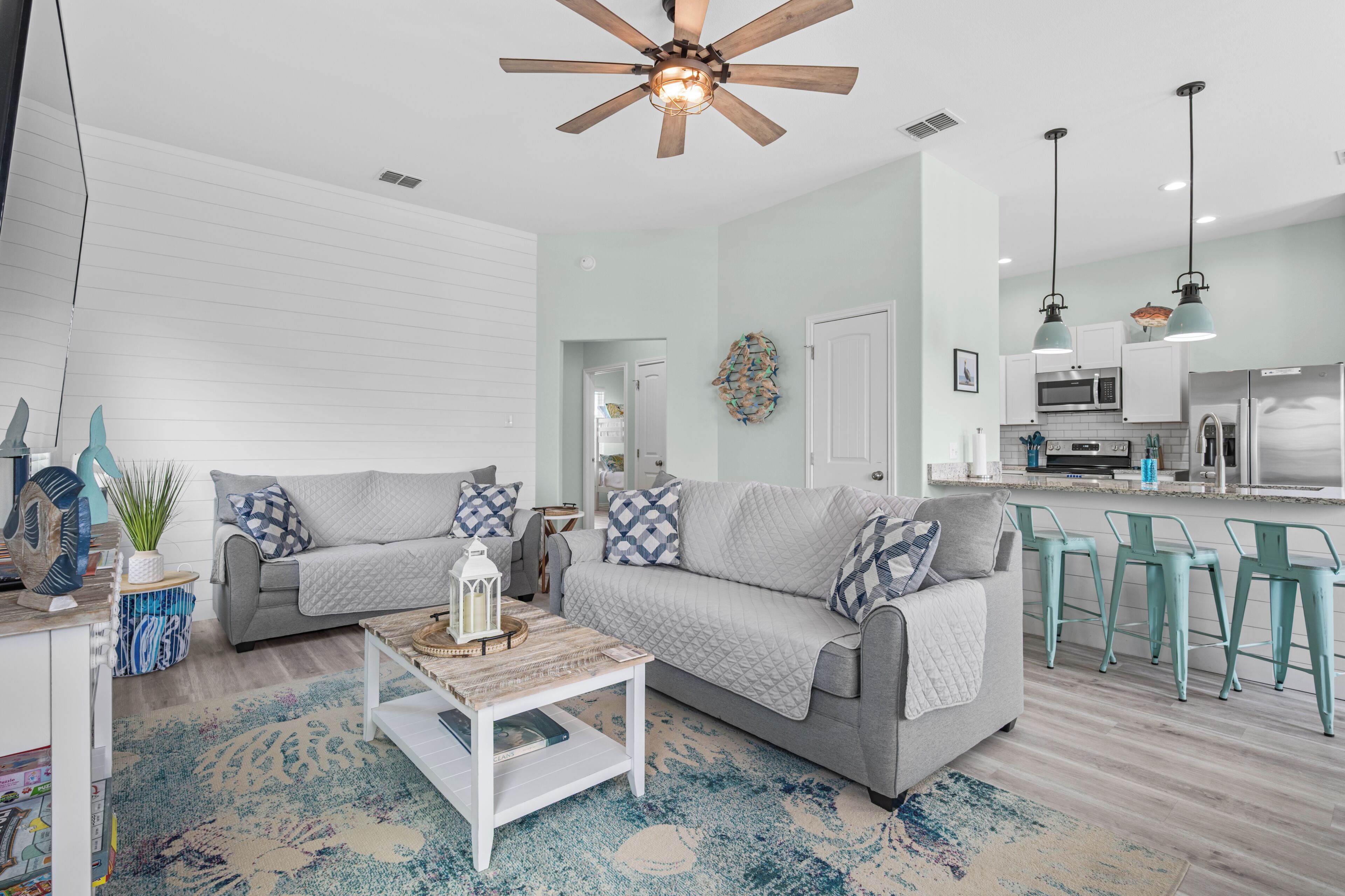 A modern living room with a sofa, coffee table, and a ceiling fan.