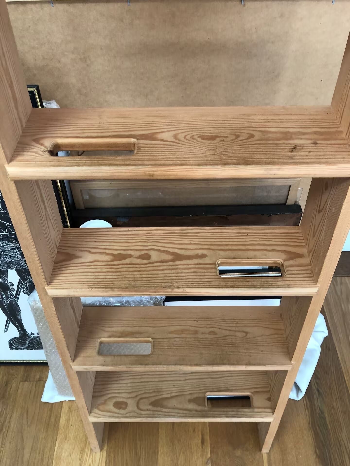 A wooden shelf unit with multiple compartments and handles.