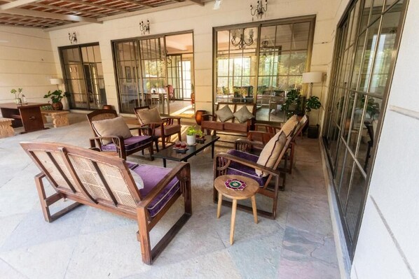 Un amplio espacio interior con diversas opciones de asientos, incluyendo sofás y sillones, y ventanas grandes que dejan entrar luz natural.