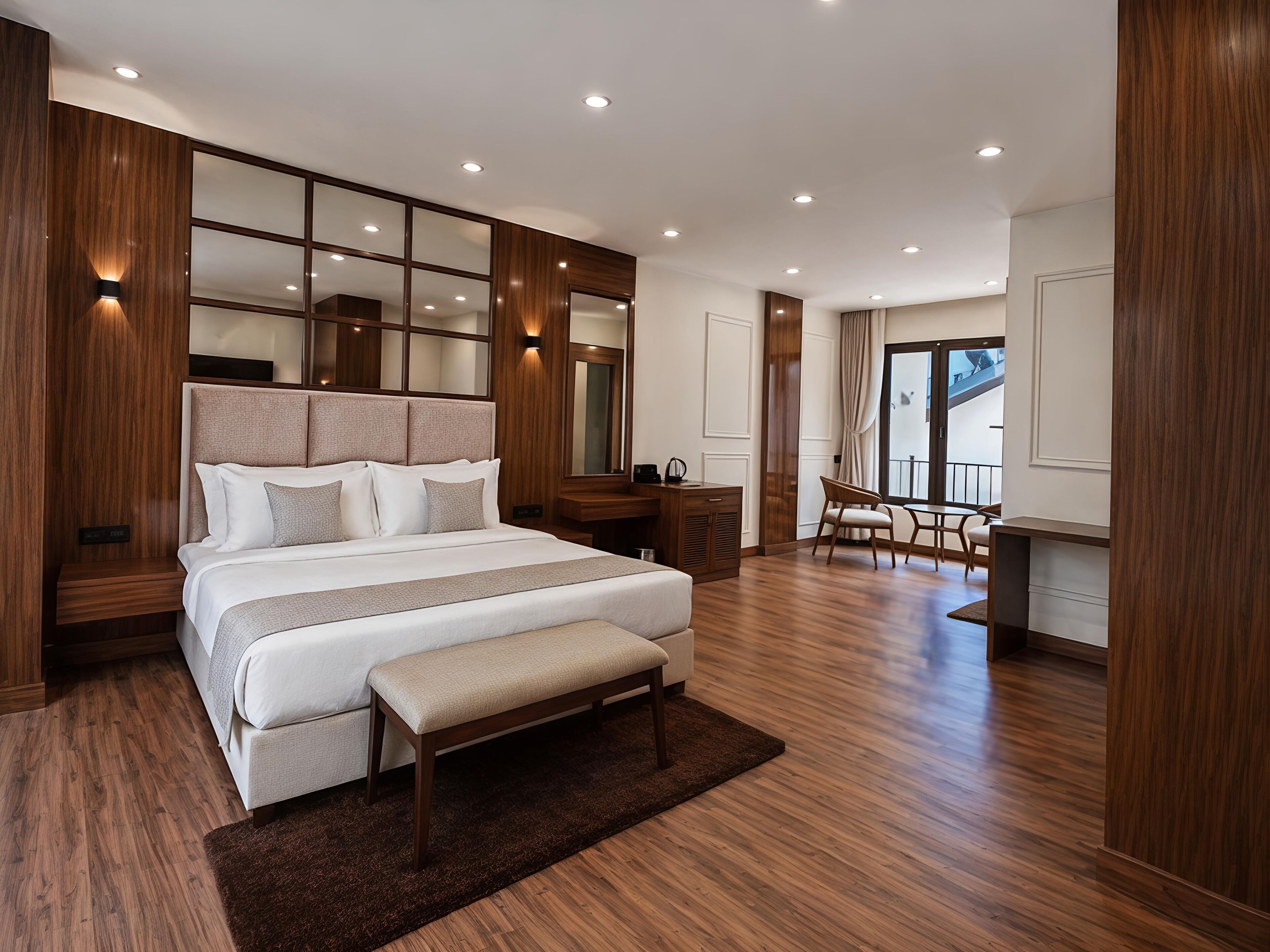 A modern hotel room with a large bed, a desk, and a view of the outdoors.