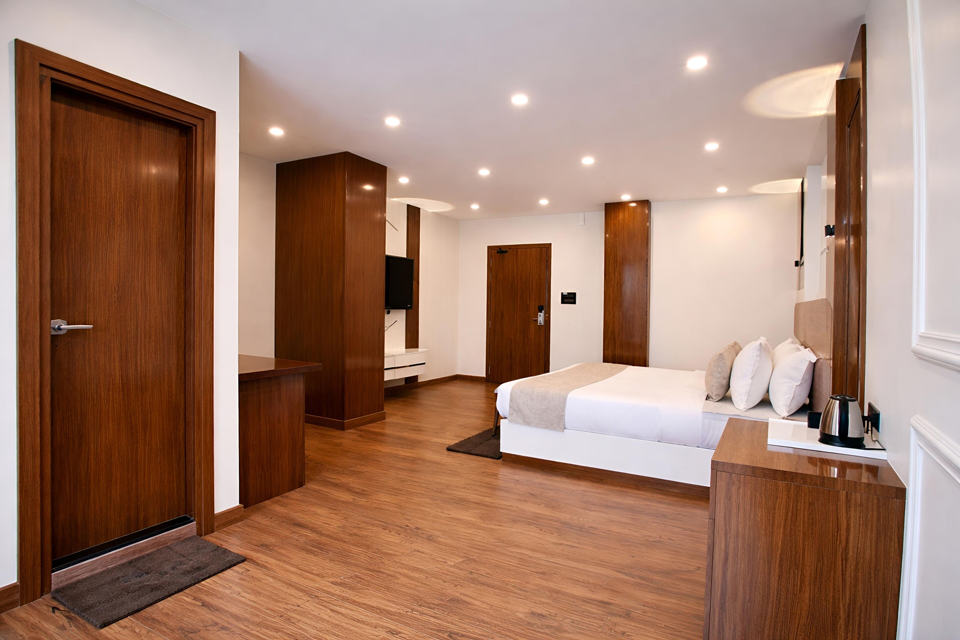 Une chambre moderne avec un lit, une armoire en bois et un bureau avec une lampe.