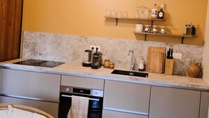 Eine moderne Küche mit Einbauofen, Geschirrspüler und einem Holztisch.
