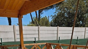 Eine Holzterrasse mit einer weißen Couch und einer Schaukel.