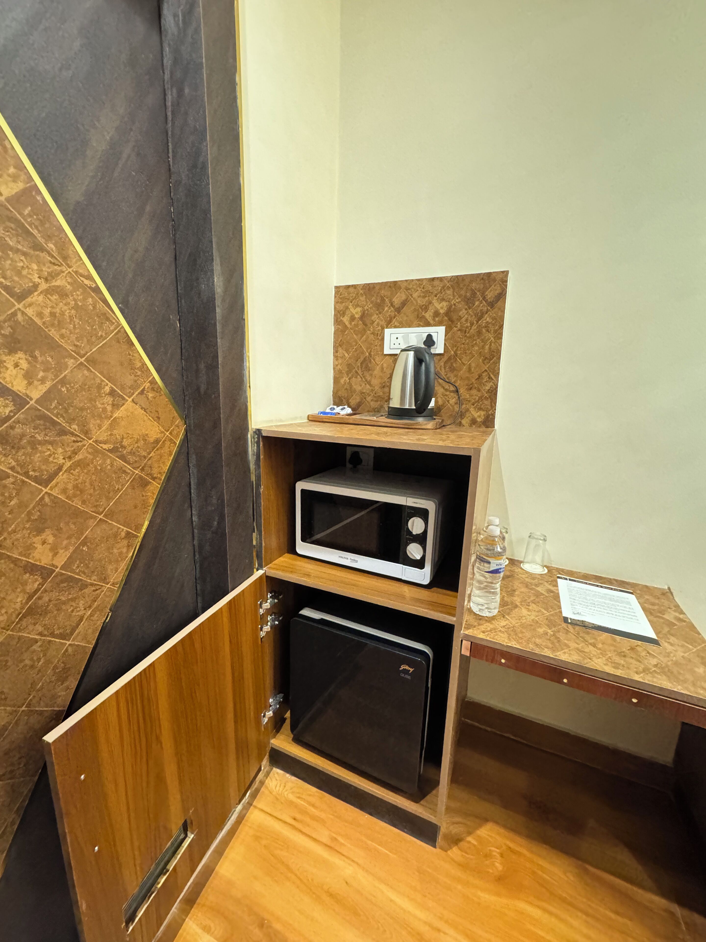 Une petite cuisine équipée d’un four à micro-ondes, d’une bouilloire et d’un petit réfrigérateur.