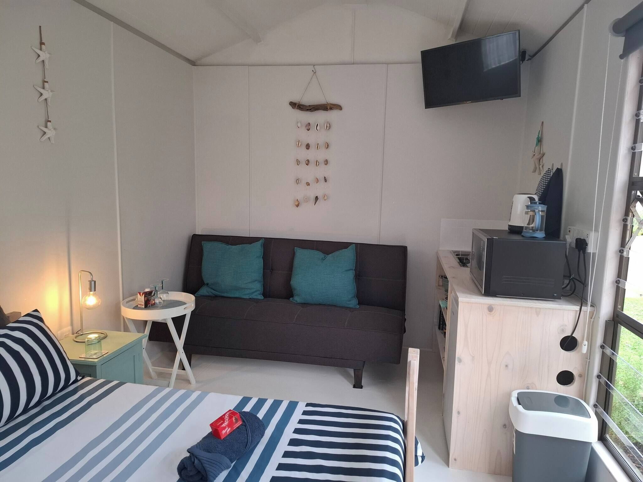 Une pièce de taille modeste comprenant un lit, un canapé, une télévision et une petite table.