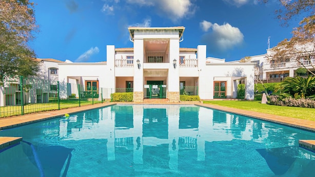 A swimming pool with a building in the background. - 3 bed Cluster home in Sandton (Sandton)